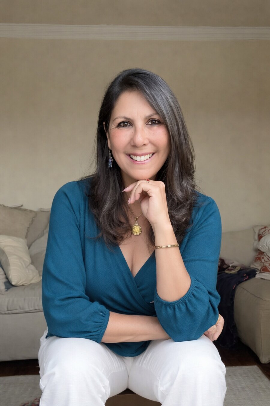 Dri Coñde sorrindo, sentada e vestindo blusa azul
